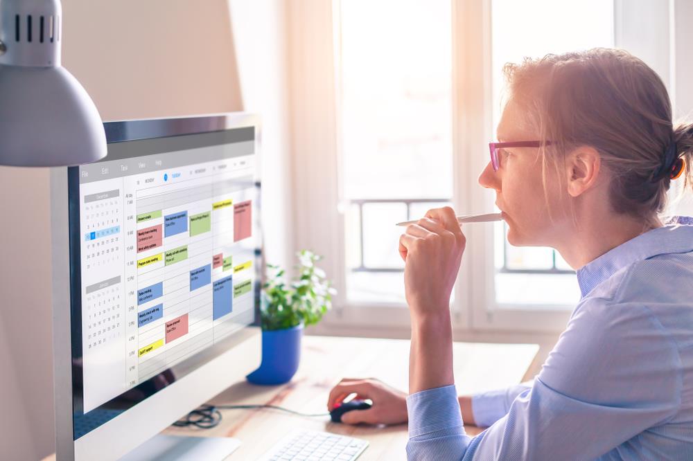 person with multiple jobs updating her schedule on her computer