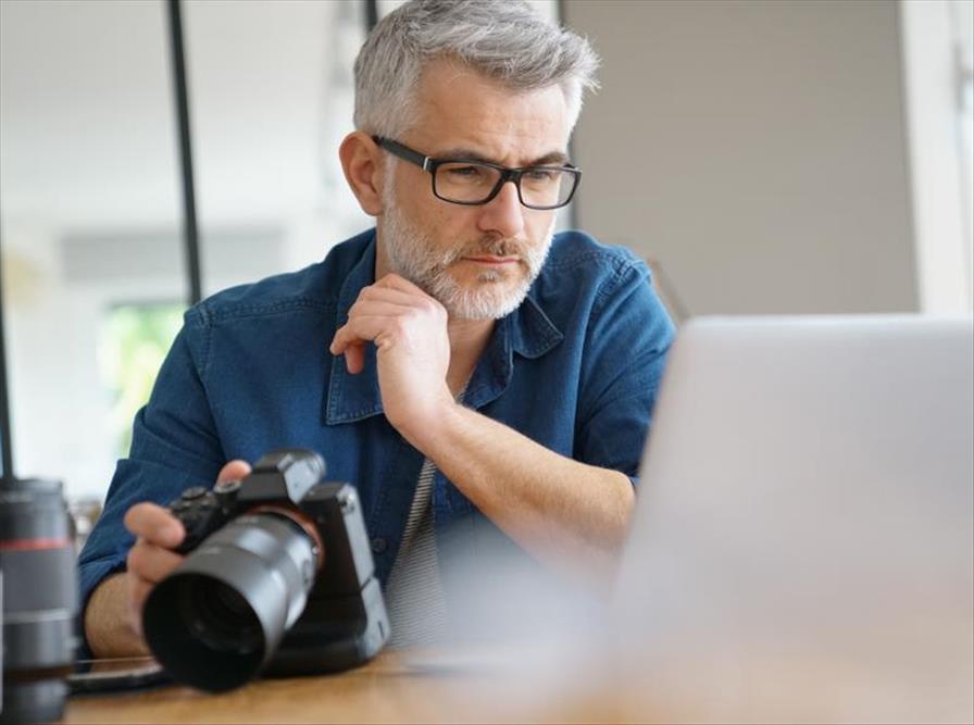 Man considers image file quality as he edits on his computer