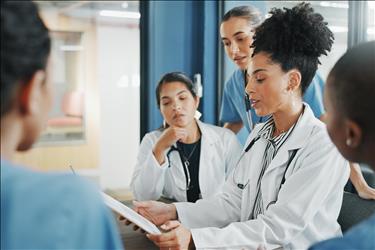 doctor going over charts with her team in a meeting