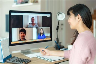 Person in front of a computer monitor being interviewed via the web.