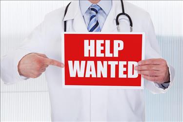 Doctor holding help wanted sign