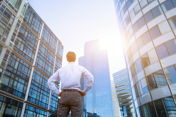 Optimistic job seeker looking up at skyscrapers