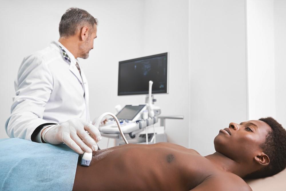 diagnostic medical sonographer performing an abdominal ultrasound exam on a patient