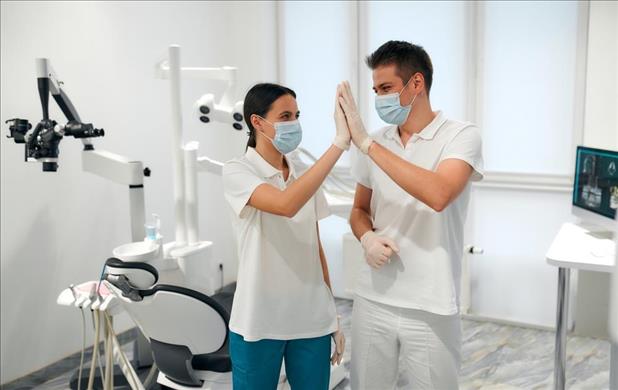 two dental team members high fiving