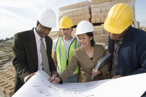 Project managers and superintendents looking at building plans on site