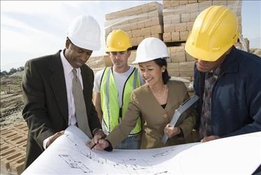 Project managers and superintendents looking at building plans on site