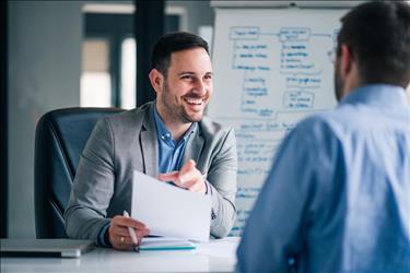 Hiring manager smiling, impressed with candidate's resume