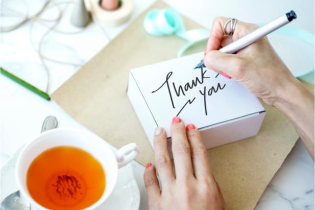 person writing a thank-you note