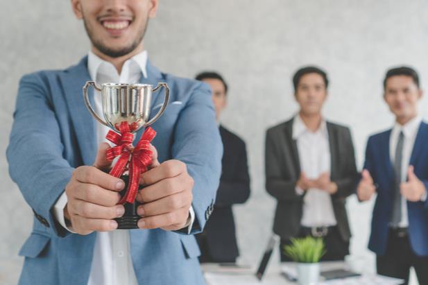 employee holding a trophy