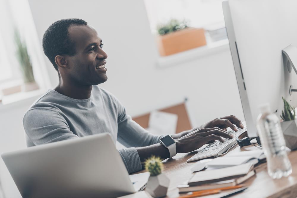 man working from home on his desktop computer