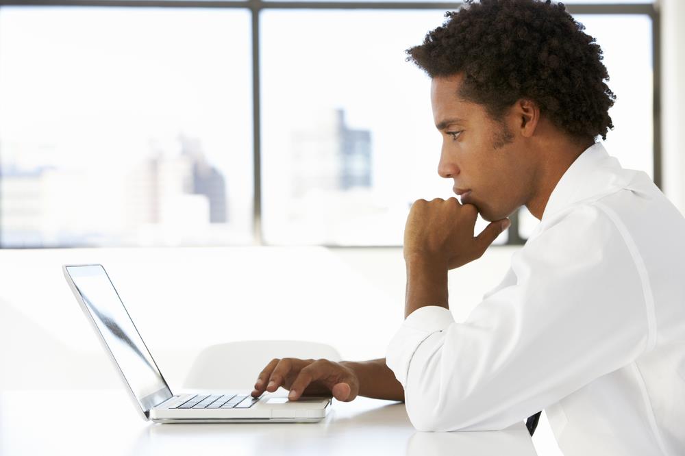 Professional looking at his computer screen thoughtfully