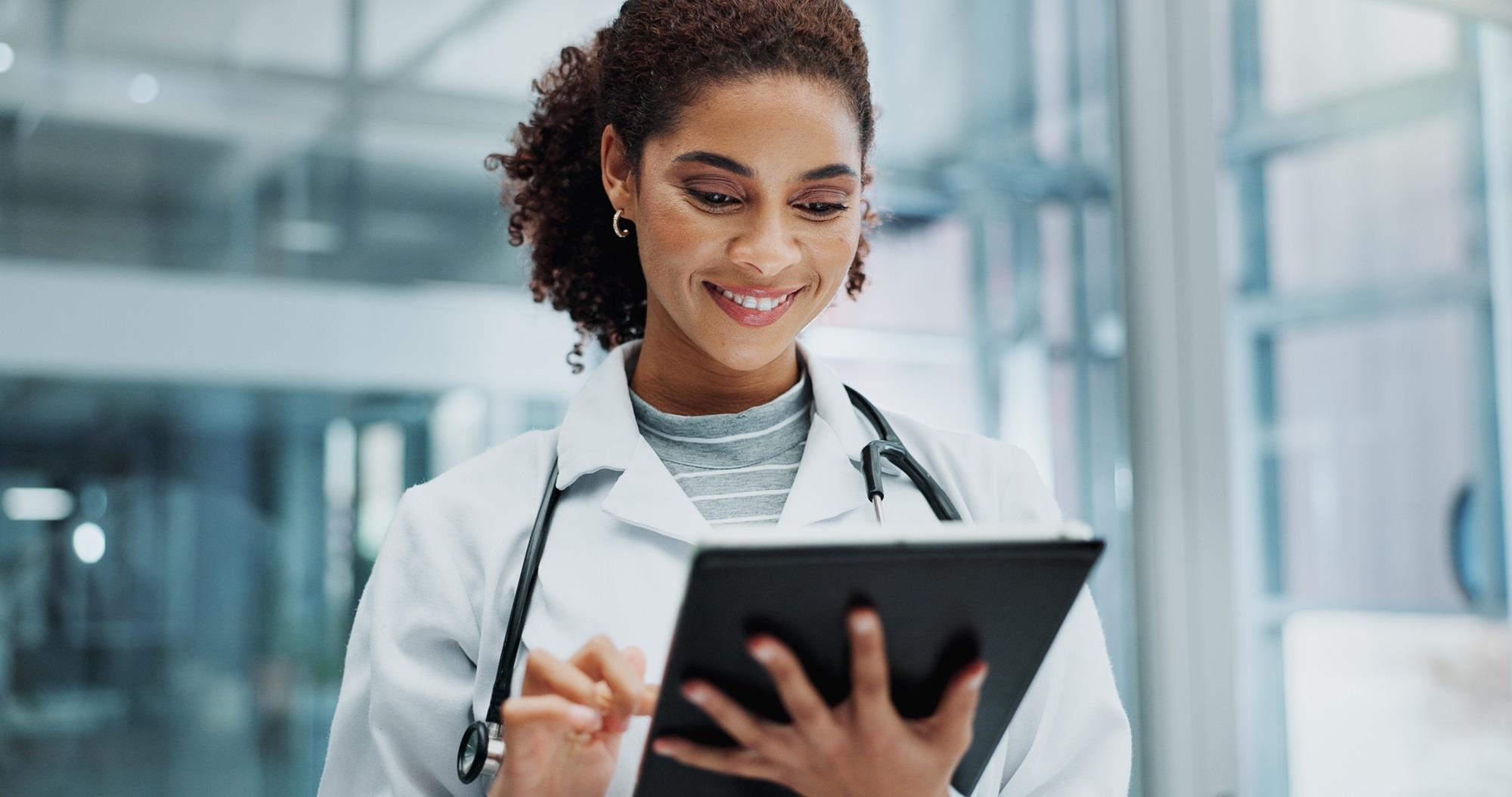 happy doctor looking at her tablet