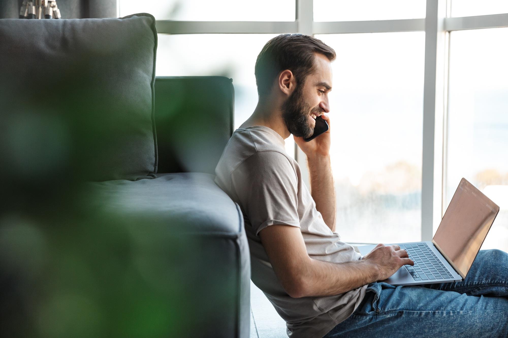 freelancer smiling while talking to a client on the phone