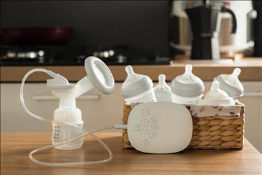 electric breast pump and bottles sitting on a table