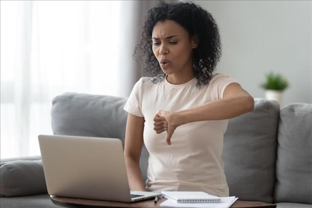 Woman putting thumbs down to something on computer