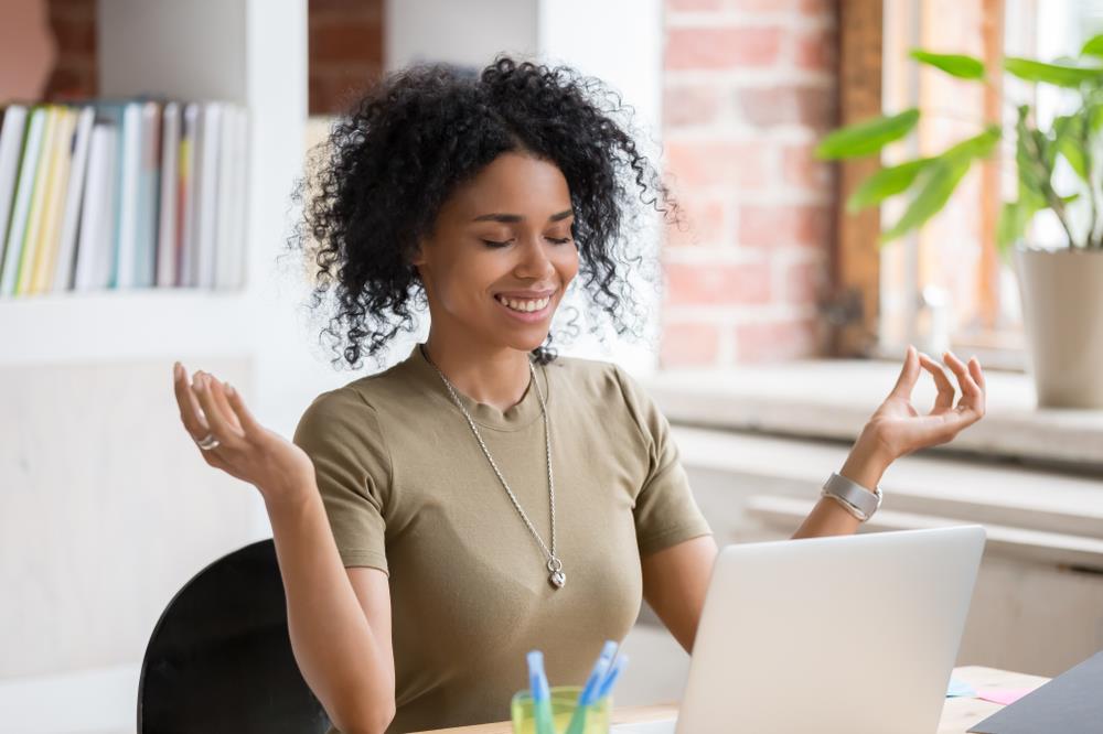 job seeker taking a break from searching for jobs online to meditate and find a positive attitude