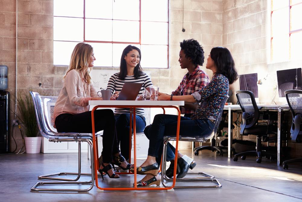 group of coworkers talking in modern office