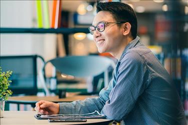man smiling in a conference area