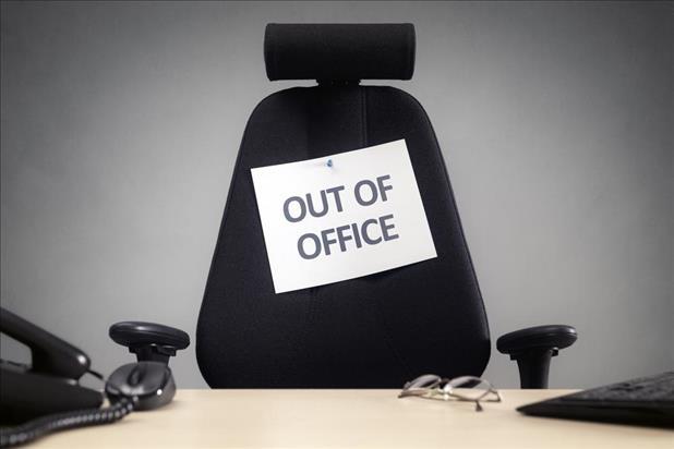 empty office chair with "out of office" sign on it