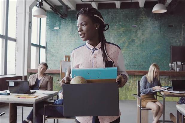 employee leaving work on her last day with a box full of her items