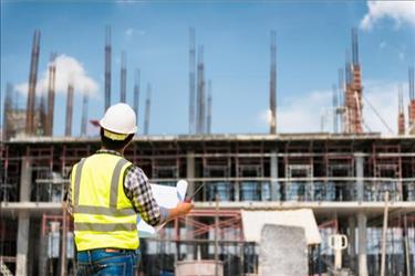 construction worker looking at building