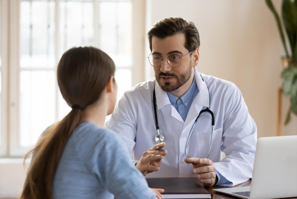 doctor talking to patient at desk