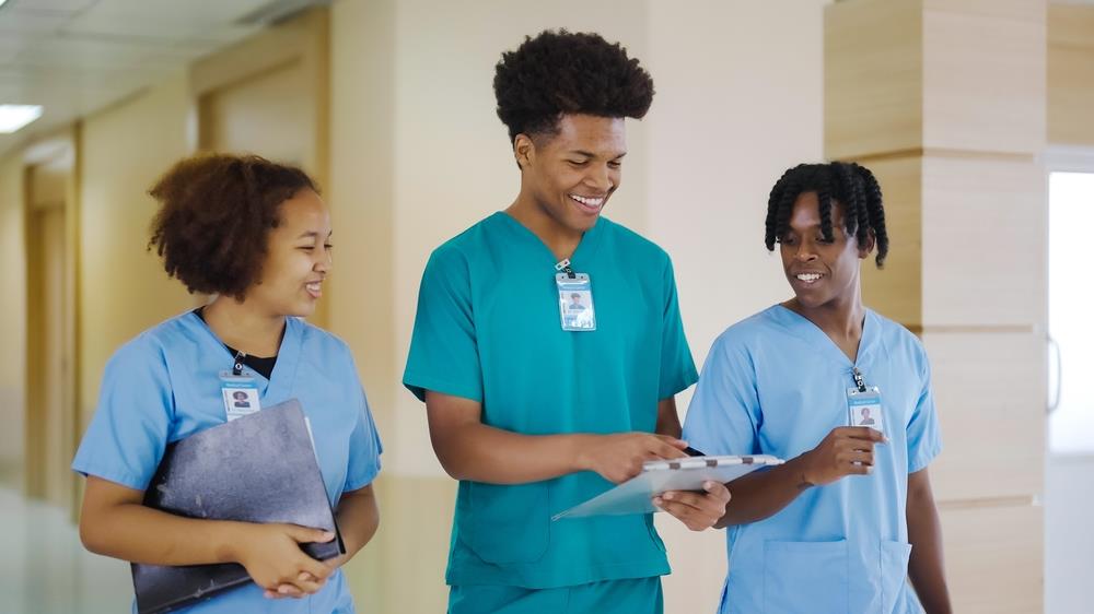 3 young healthcare workers walking in hospital