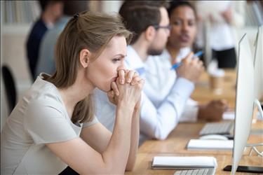 unhappy employee sitting with her colleagues