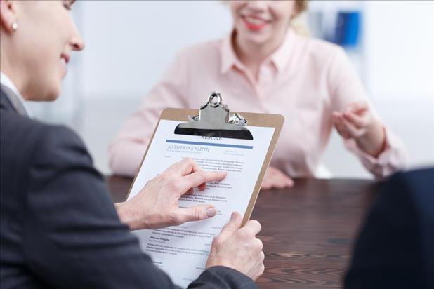 job seeker at an interview while the employer reviews her resume keywords