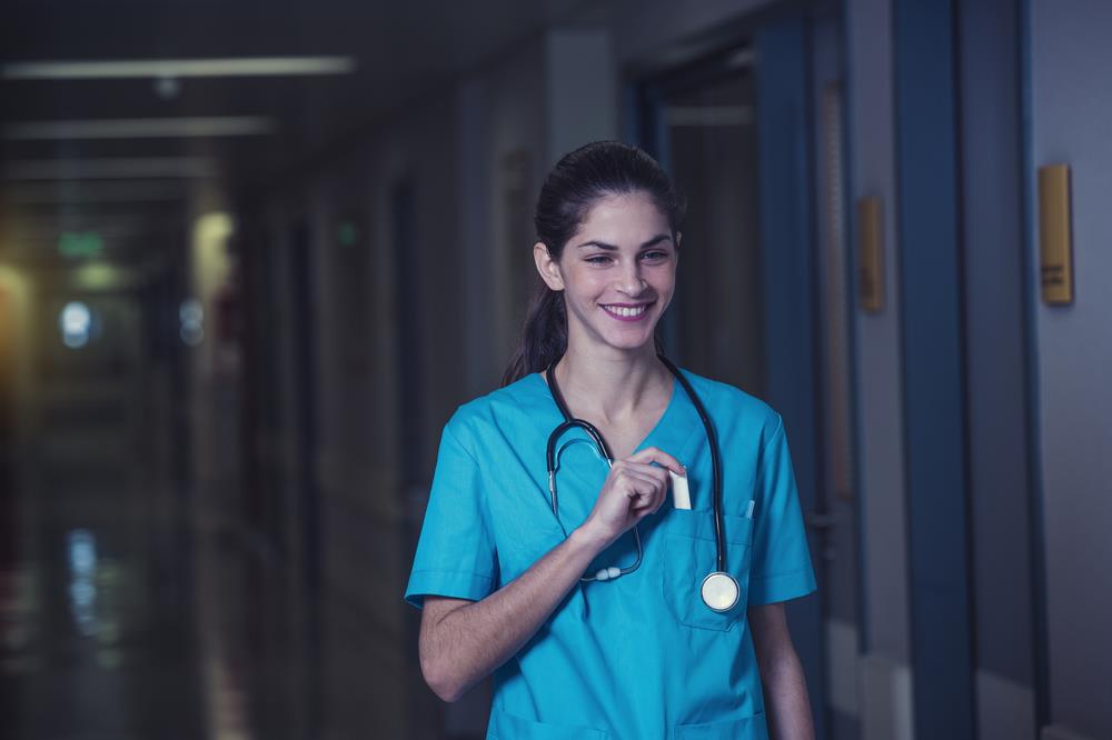 happy night shift nurse walking down the hospital hallway