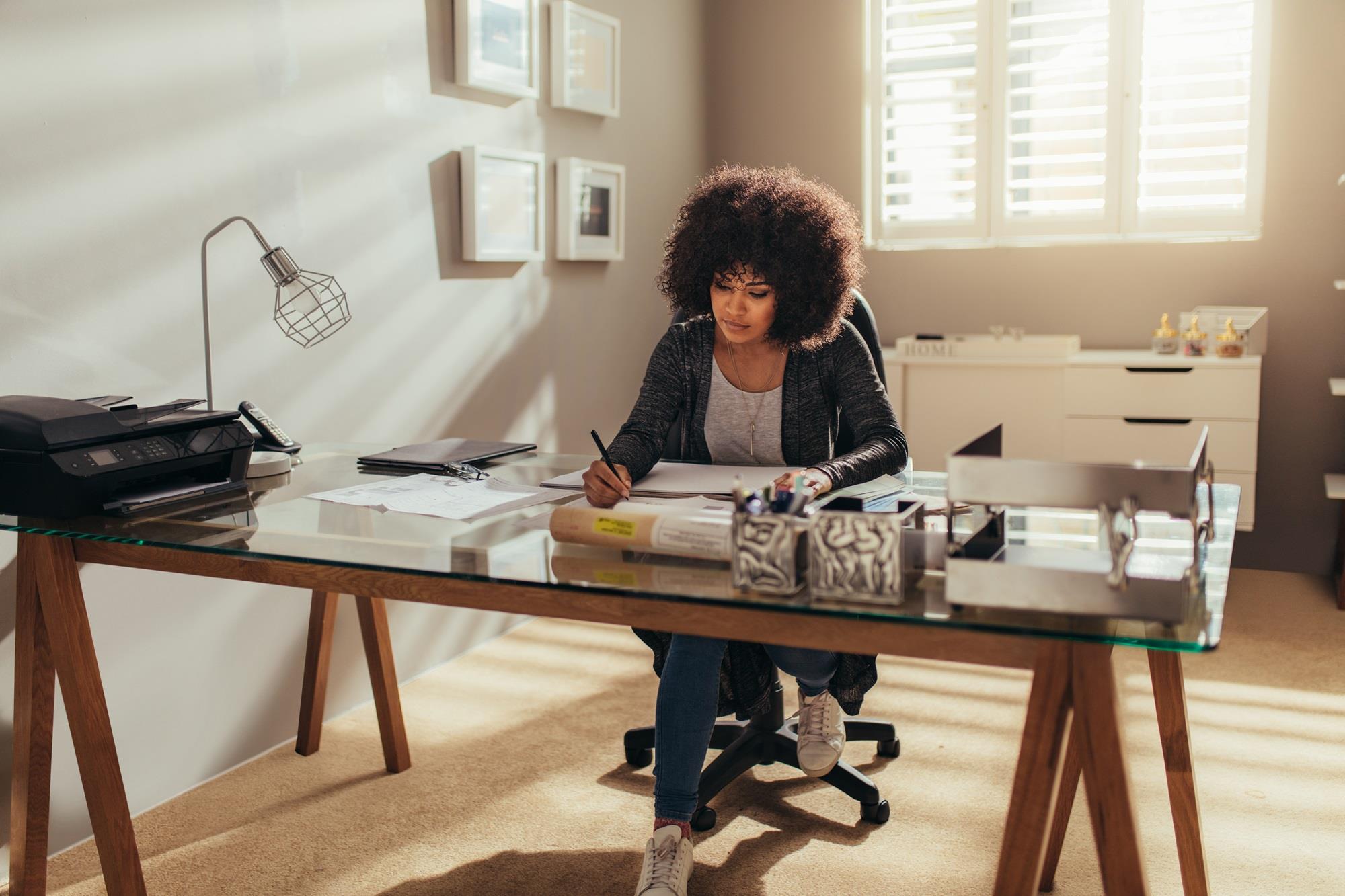 woman writing at her home office desk