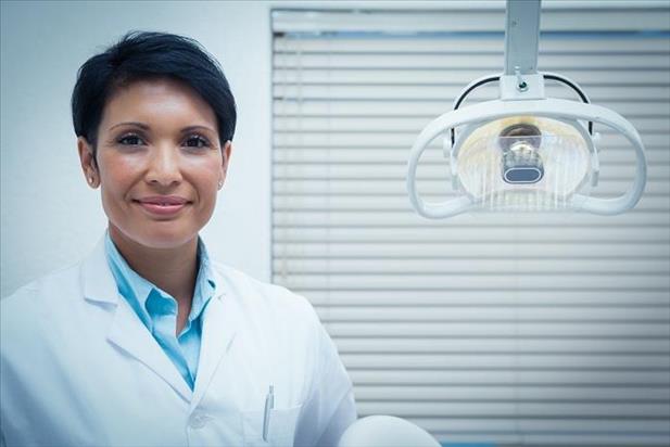 Portrait of a dentist posing in her practice