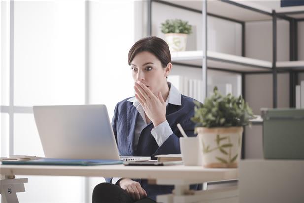 woman at her desk looking at a typo in her resume on the computer