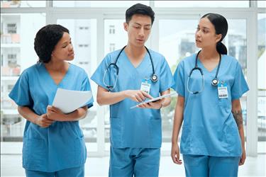 nurse educator speaking with two nurses in a hospital
