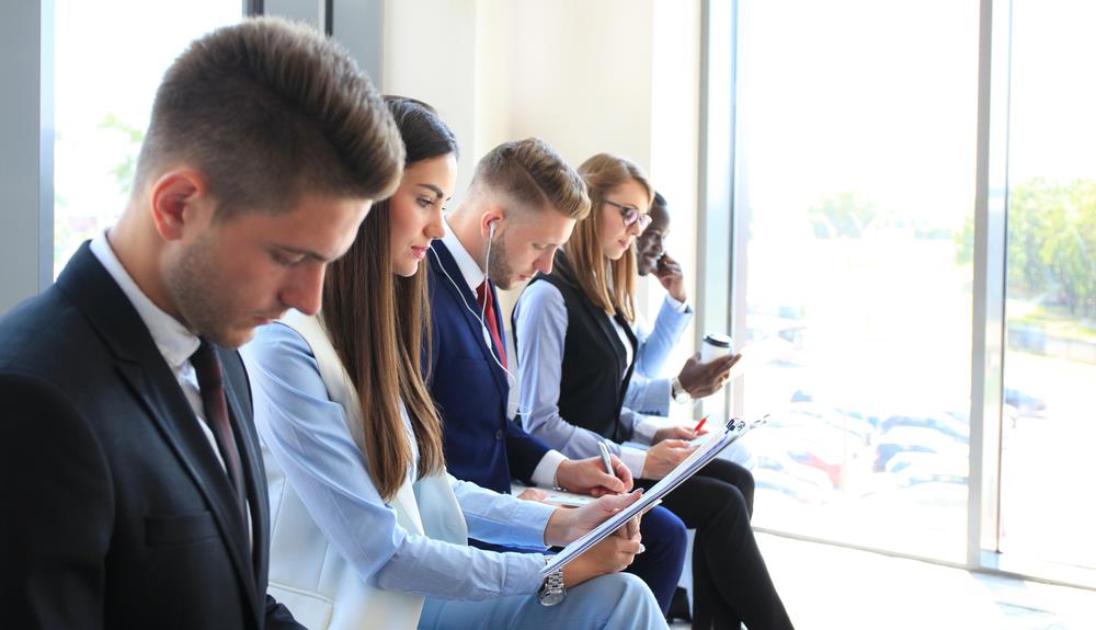 job seekers lined up outside of an office waiting for their interviews