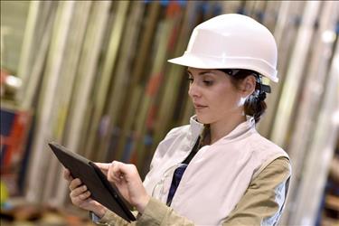 construction executive at a job site referencing her tablet