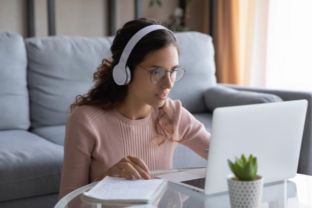 woman looking at computer with headset