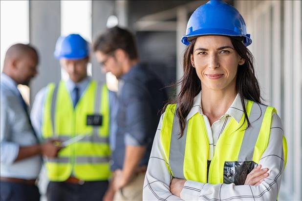 group of construction workers with woman in a blue hardhat smiling