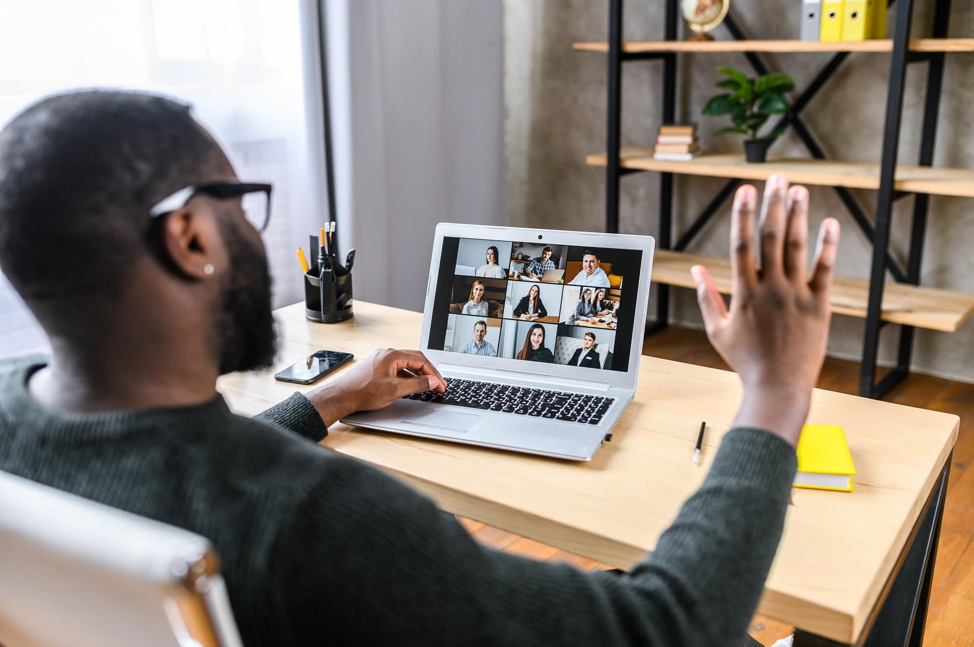 freelance employee attending a virtual meeting on his laptop