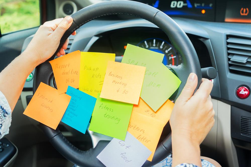 Sticky notes with tasks on steering wheel