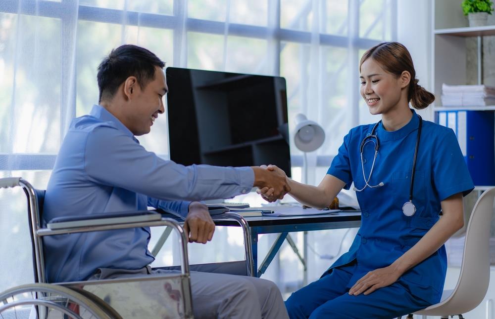 Nurse talking to man in wheelchair