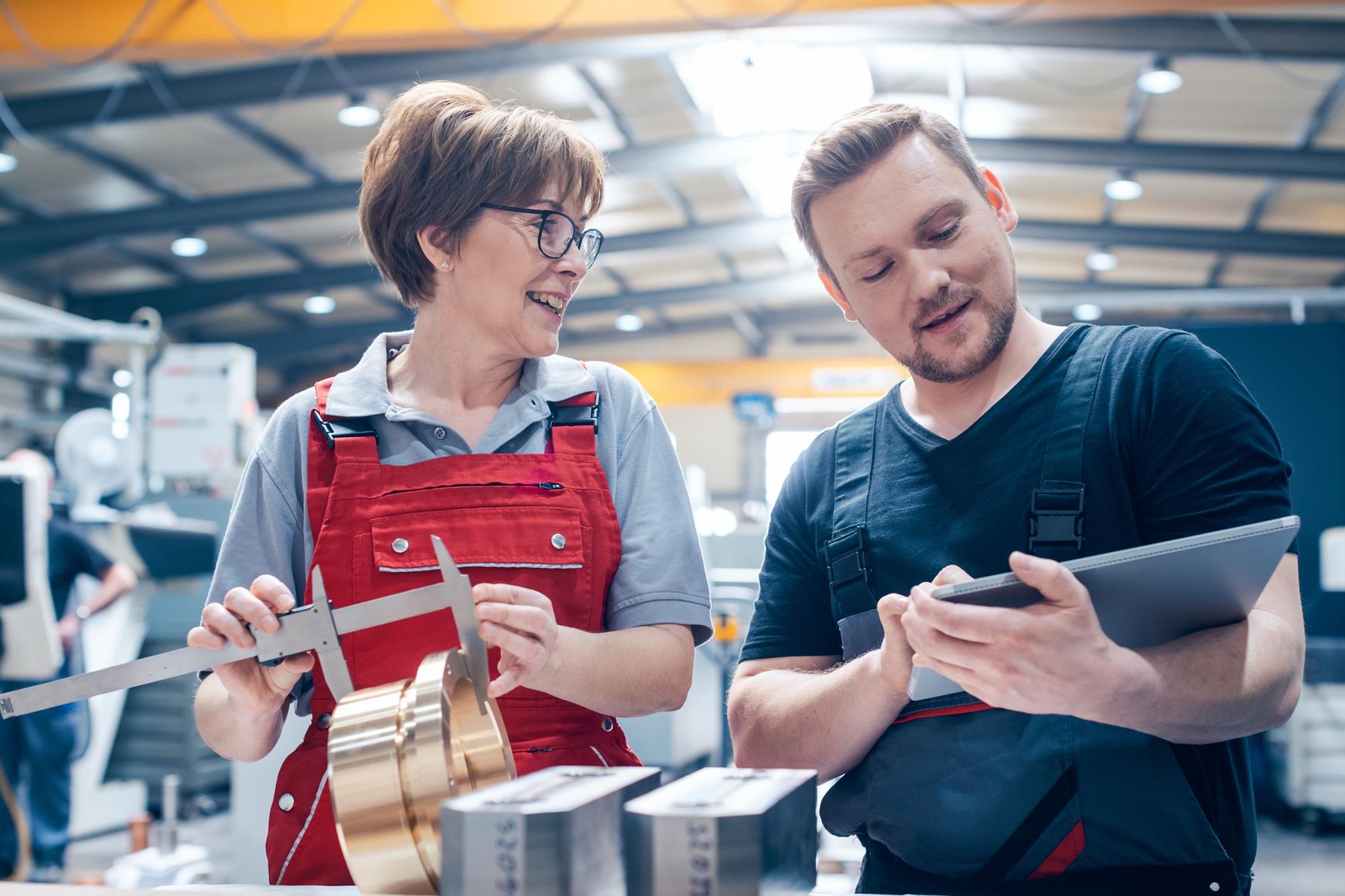 two happy factory employees working together