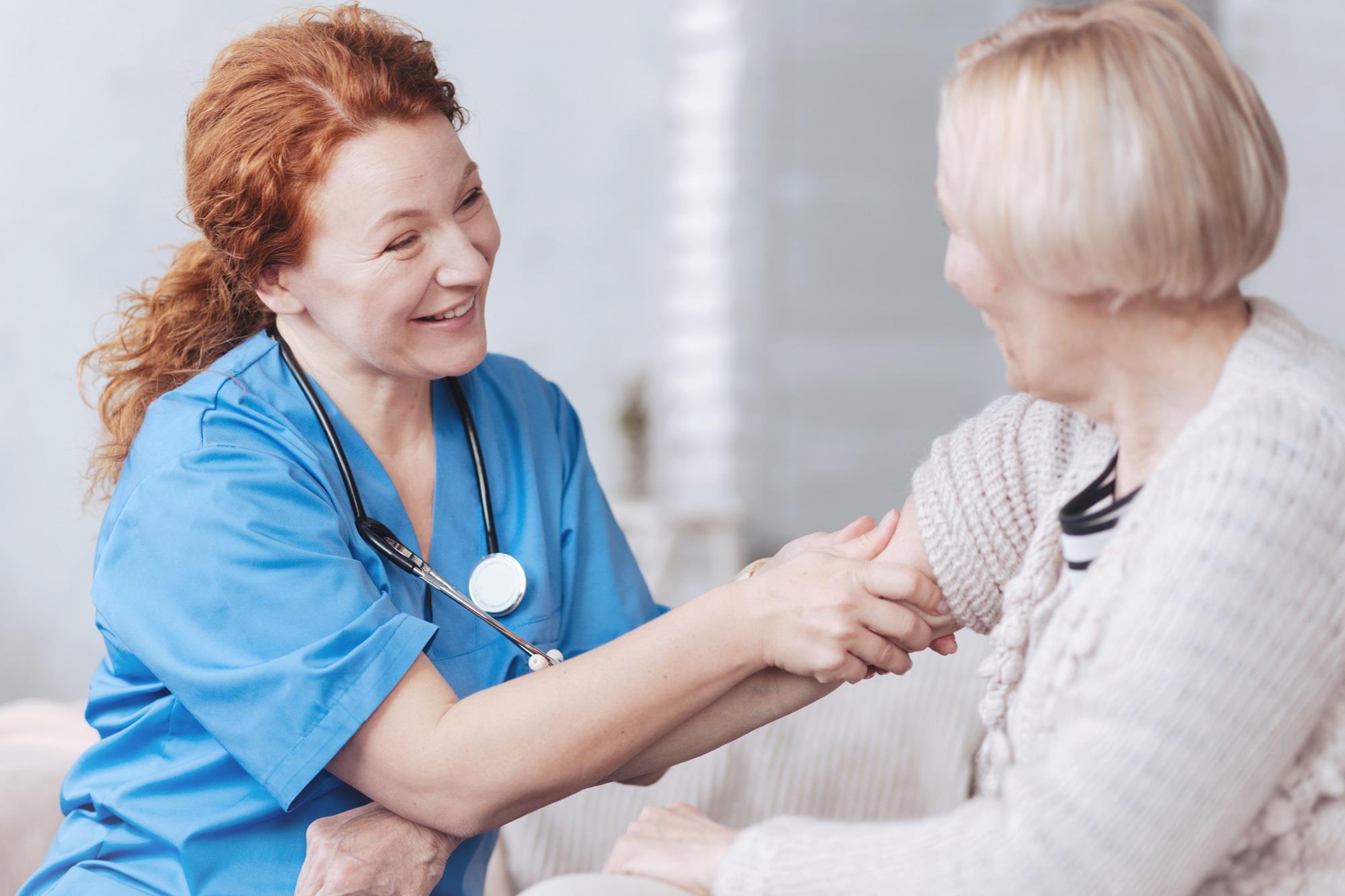 nurse smiling while caring for her patient