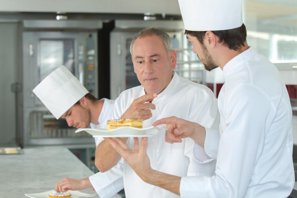 Culinary instructor teaching a chef student