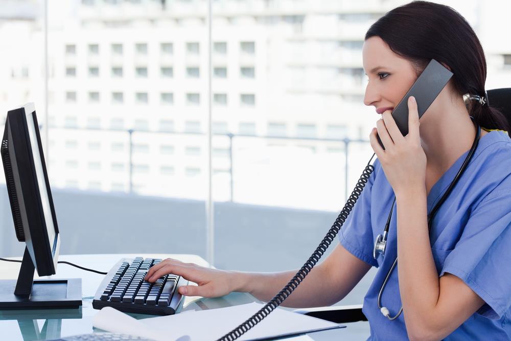 telenurse at her desk talking to a patient on the phone