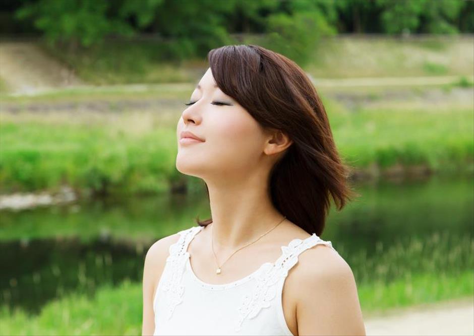 Relaxed woman goes on a walk as an opportunity to take in fresh air and sunshine.