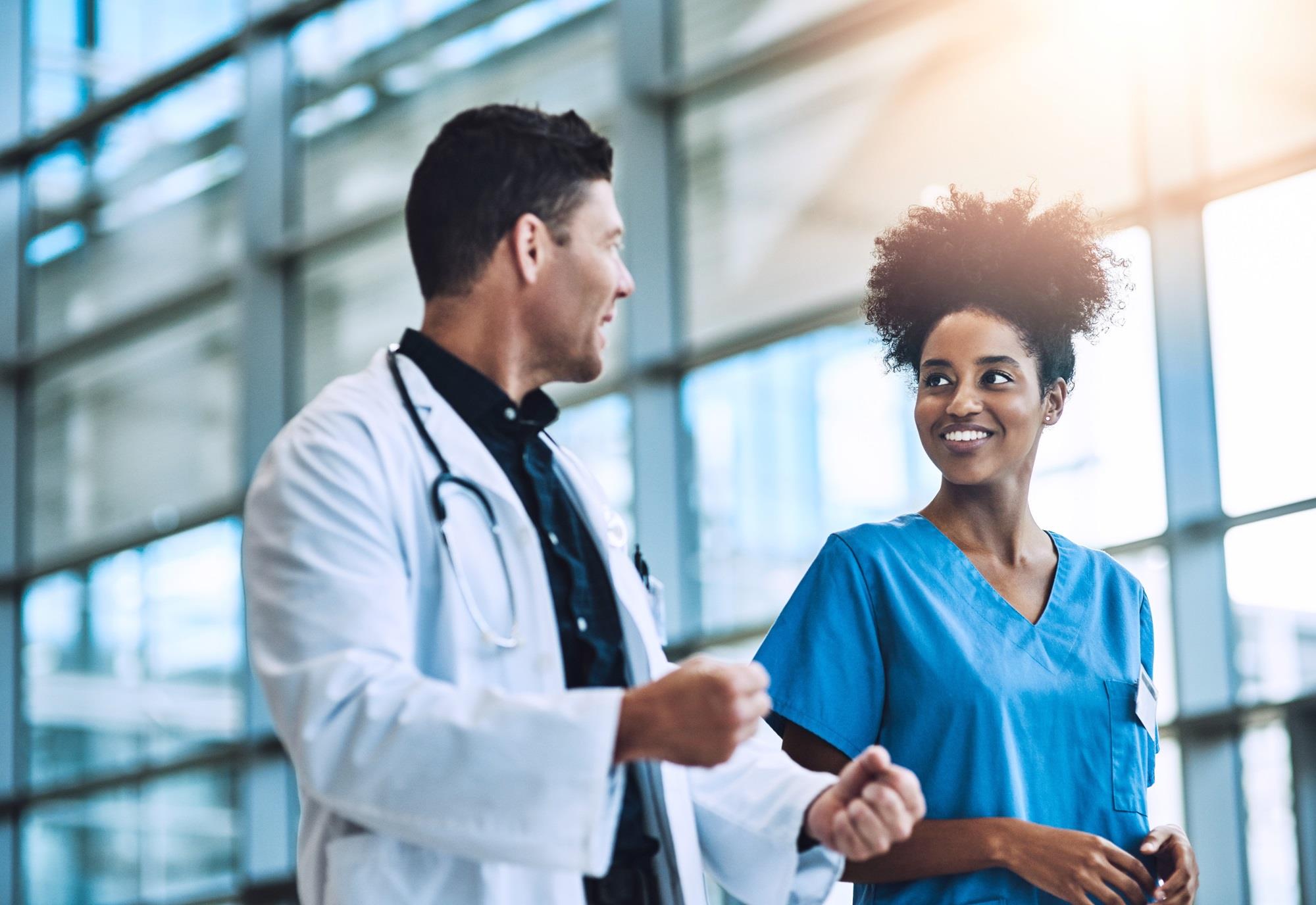 doctor and nurse talking while they walk together