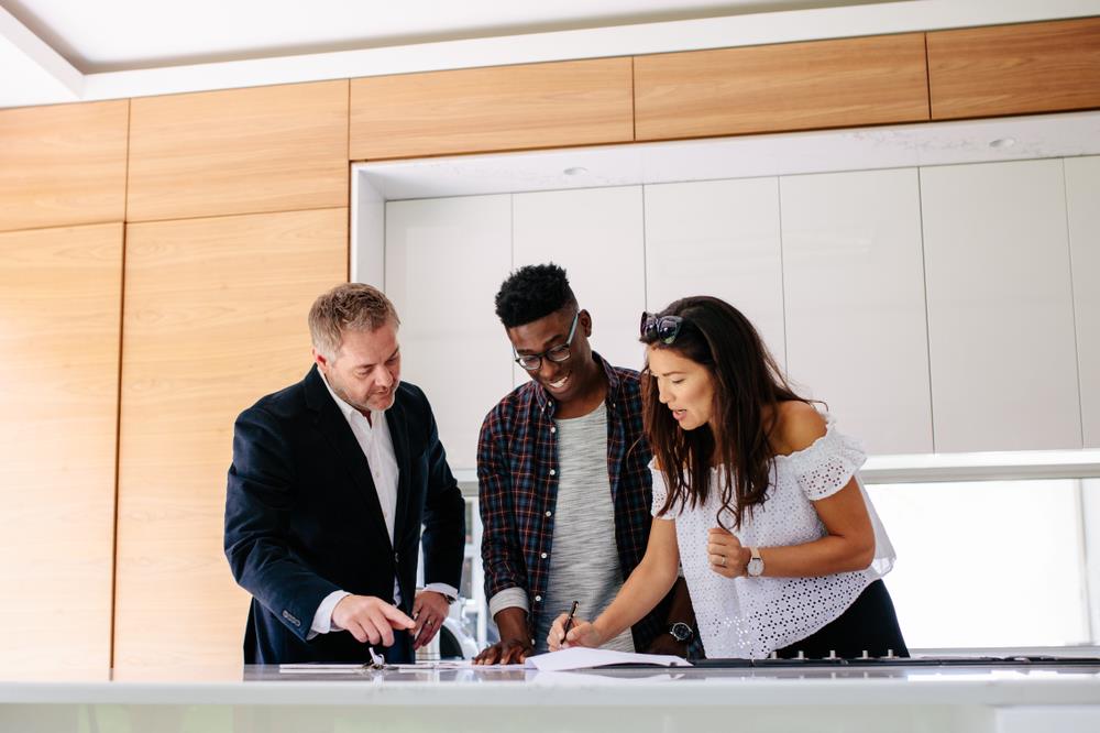 real estate agent meeting with clients inside their new home