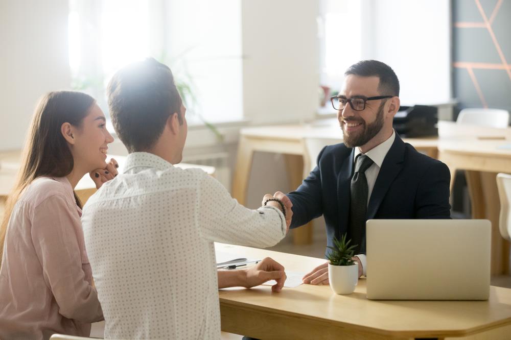 personal banker shaking the hand of a client after a successful meeting