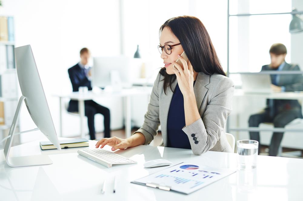 personal banker working at her desk and talking on the phone